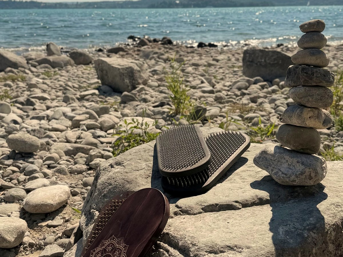 Sadhu Board und Nagelbrett am Seeufer mit Steinturm