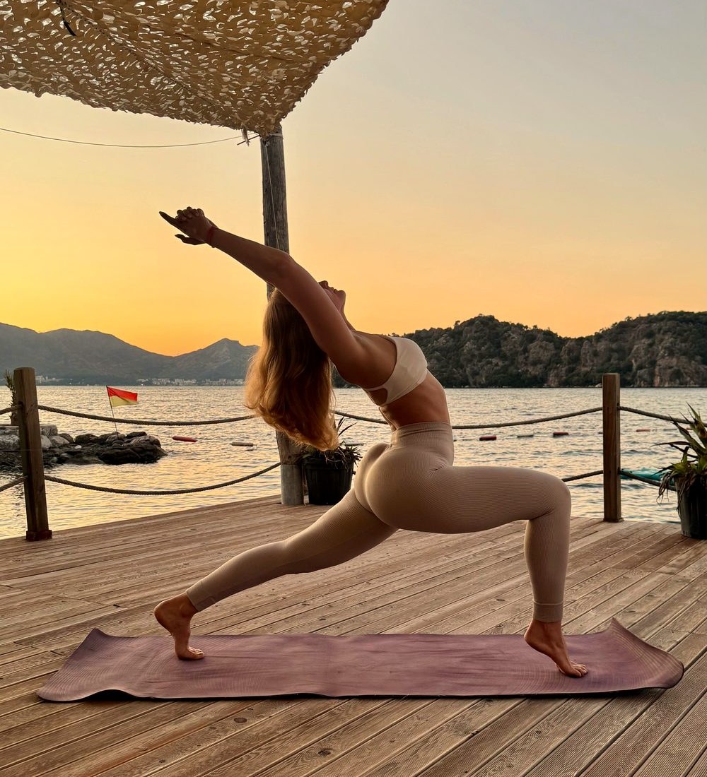 Anastasiia Mamlina in einer Yoga-Haltung am Meer